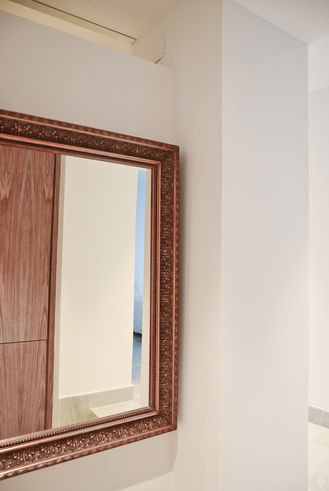 Un espejo antiguo, enfrente, refleja este diálogo, amplía el espacio, y permite a los inquilinos comprobar su apariencia antes de salir a descubrir la vieja-nueva ciudad